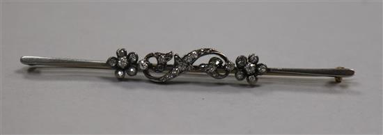 An Edwardian yellow metal and diamond set scrolling bar brooch, 76mm.